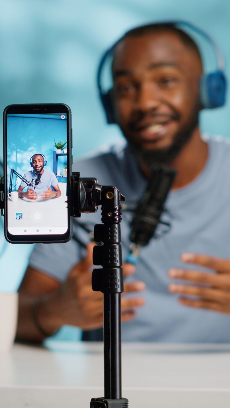 Close up of blogger filming video with smartphone on tripod